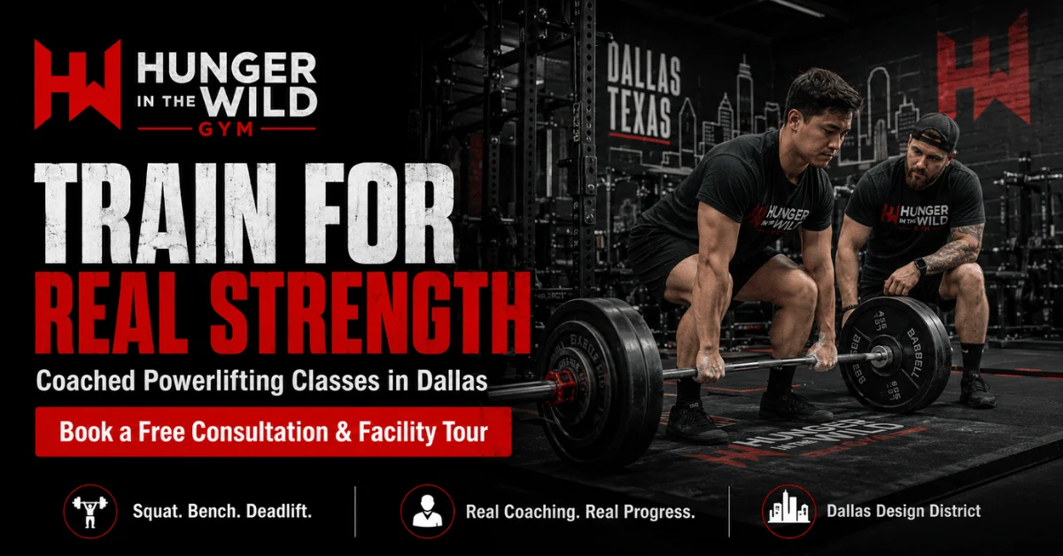 Powerlifting Classes in Dallas: How to Train for Real Strength Without Going It Alone Athlete sets up for a deadlift while a coach provides guidance at Hunger in the Wild Gym, promoting coached powerlifting classes in Dallas.