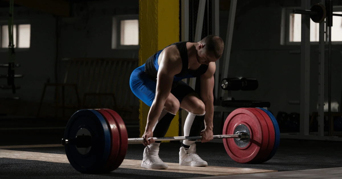 Powerlifting Classes in Dallas: How to Train for Real Strength Without Going It Alone Powerlifter prepares for a heavy deadlift on a lifting platform, gripping a loaded barbell during a focused strength training session in a gym.