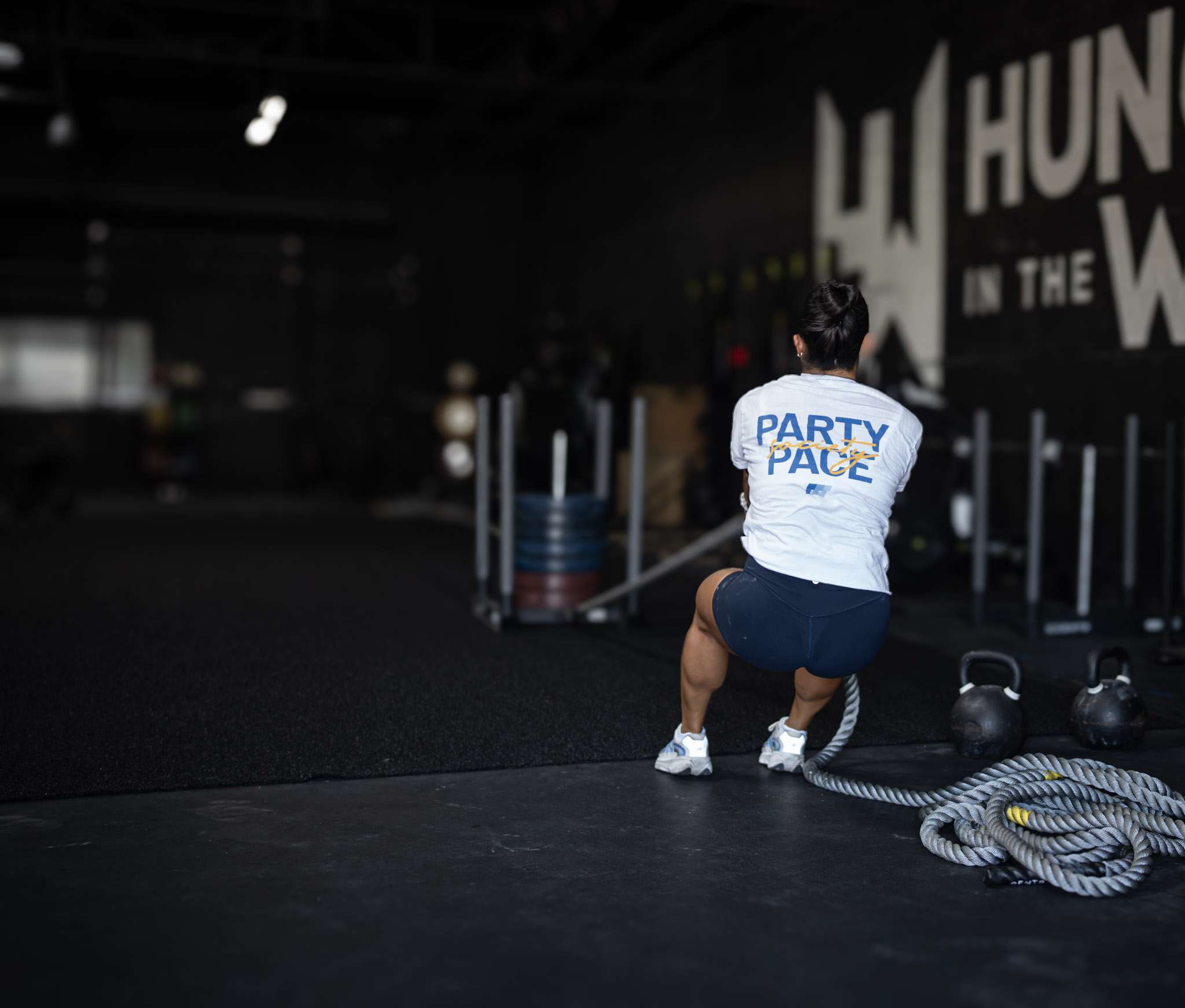 Athlete in a Party Pace shirt gripping the sled pull rope at the start of a HYROX training session at Hunger in the Wild in Dallas