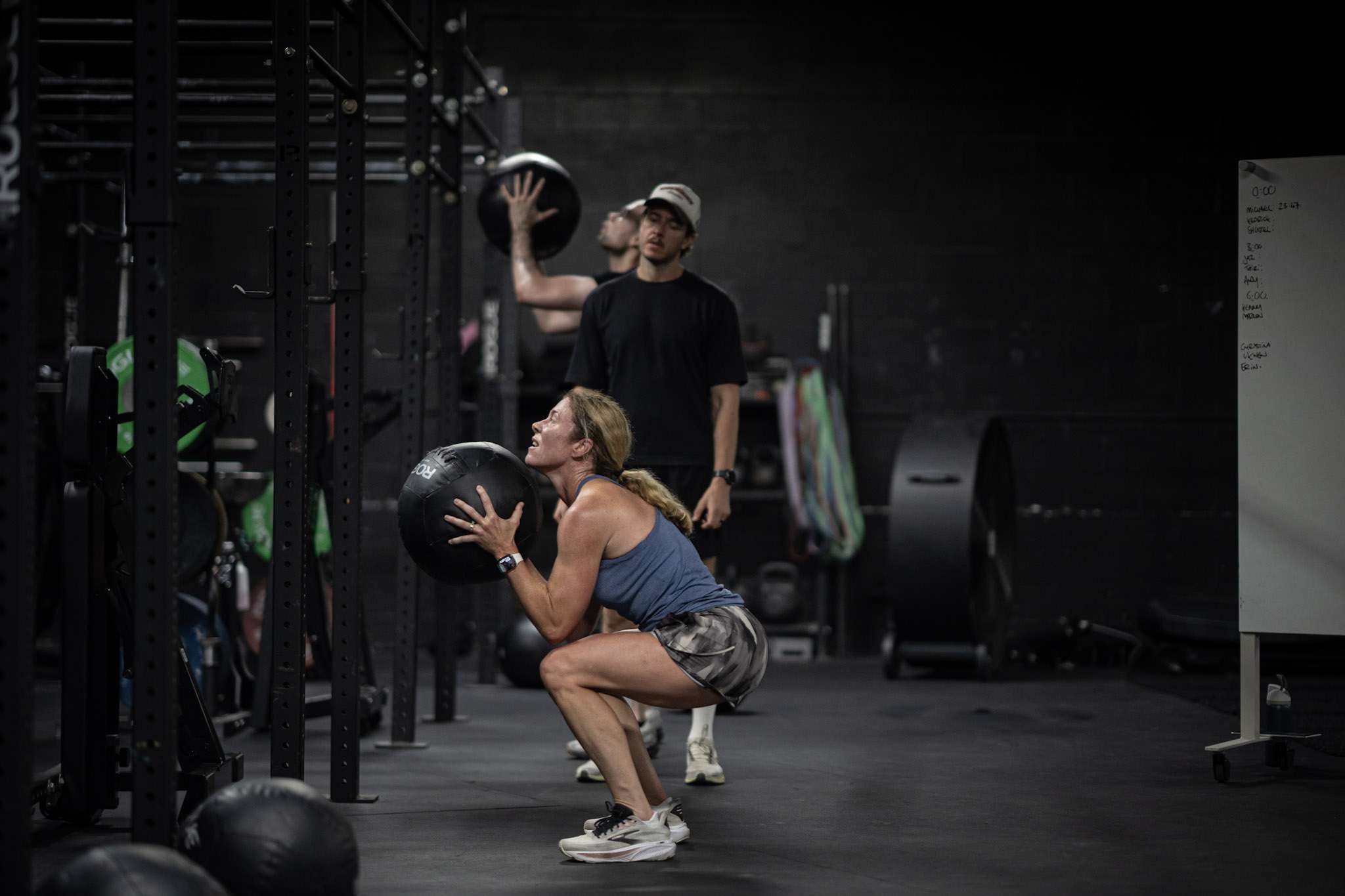 Athlete catching a wall ball into a deep squat during HYROX training at Hunger in the Wild Gym in Dallas