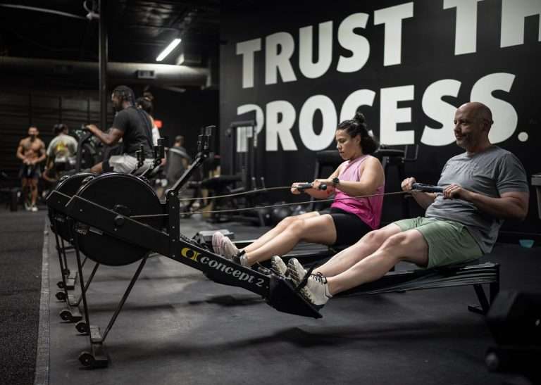 HYROX Pacing Strategy: Race Your First (or Fastest) Race Two athletes pacing 1,000-meter rowing intervals on Concept2 rowers during HYROX training at Hunger in the Wild Dallas