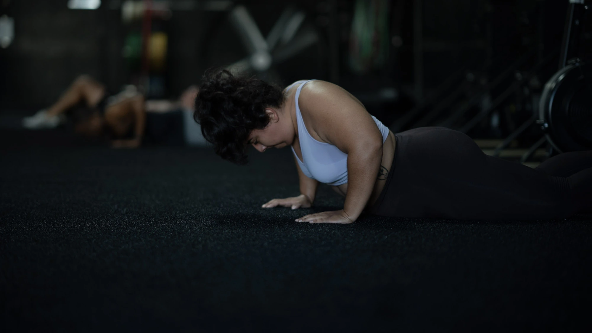 Woman performing a push-up at Hunger in the Wild Gym.