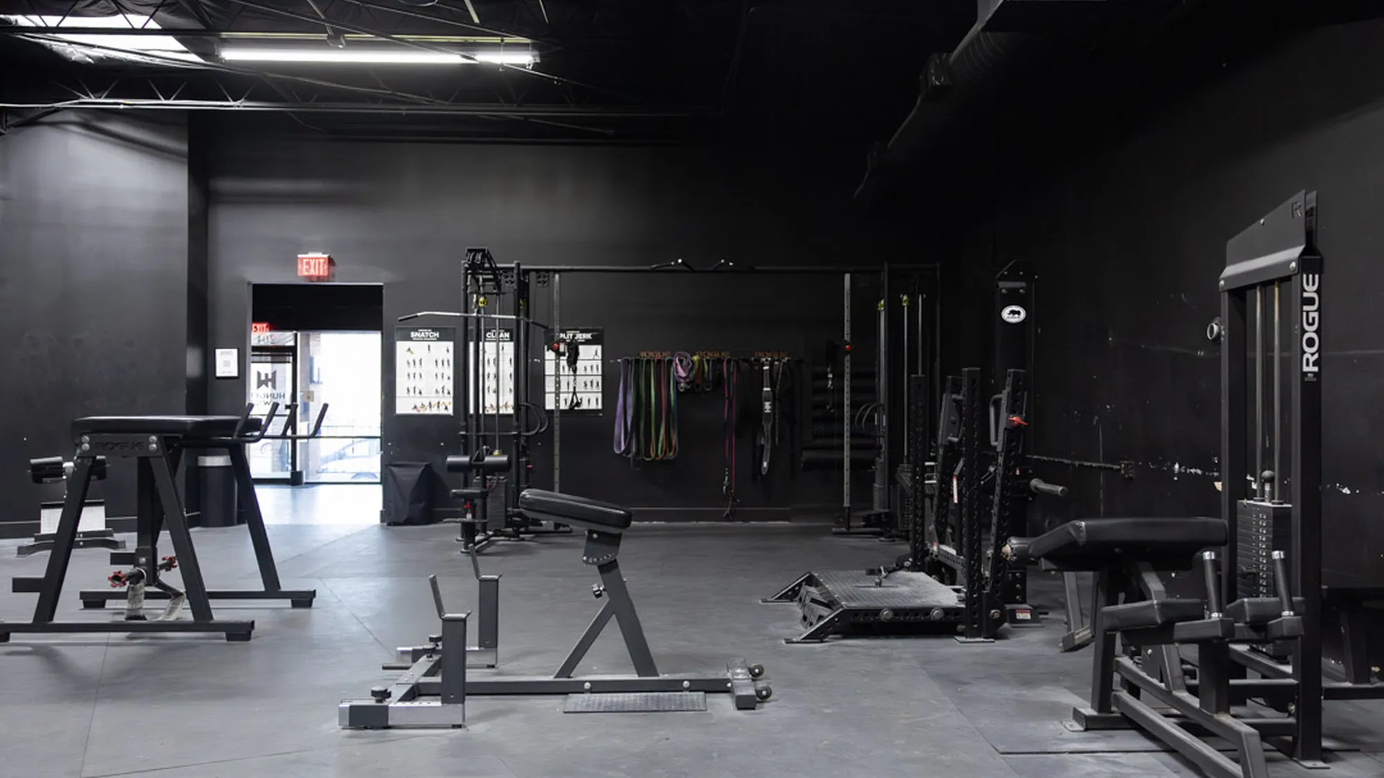 Strength training floor with racks, barbells and lifting platforms at Hunger in the Wild Gym.