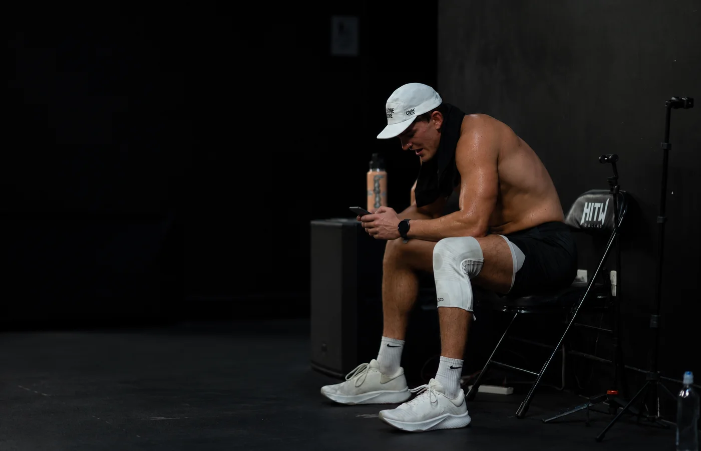 Athlete checking his training program on his phone between sets at Hunger in the Wild in Dallas