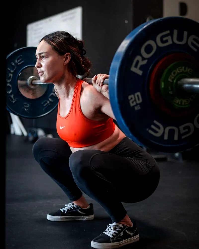 Lifter back squatting in a coached strength class at Hunger in the Wild